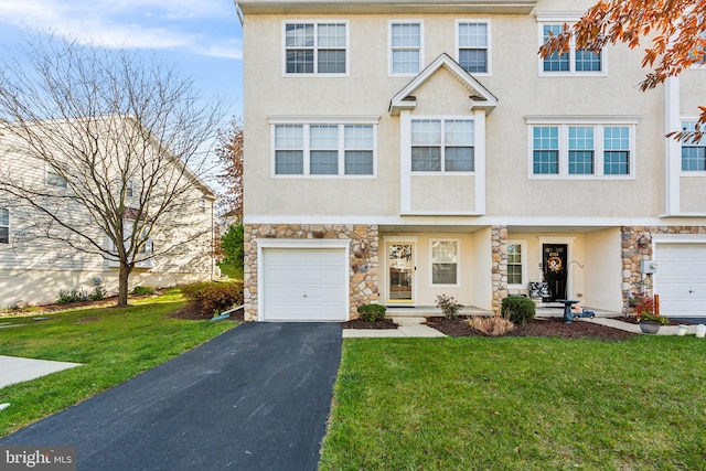 townhome / multi-family property featuring a garage and a front lawn