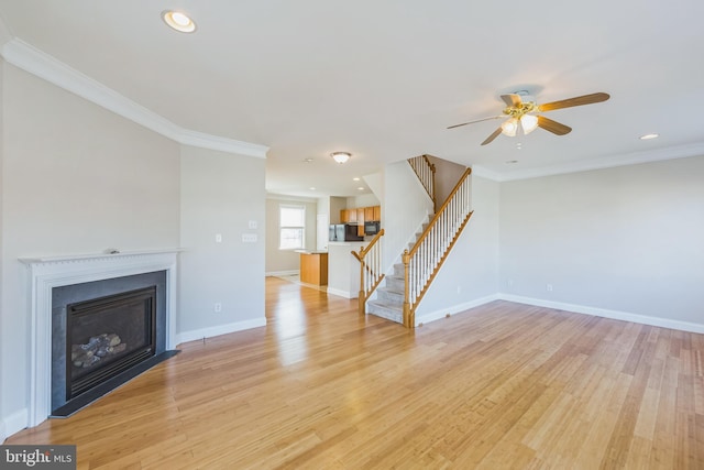 unfurnished living room with ceiling fan, ornamental molding, and light hardwood / wood-style flooring