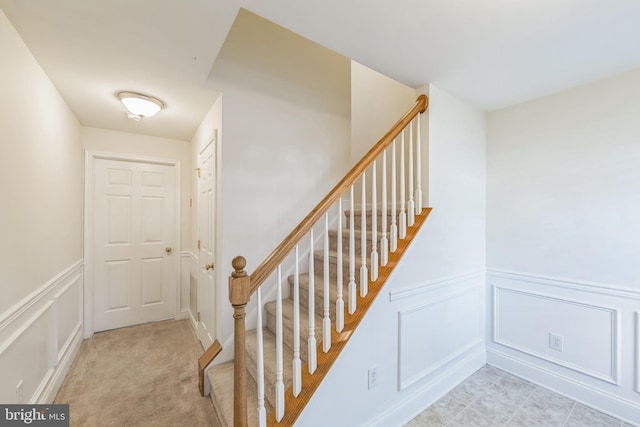 staircase featuring carpet