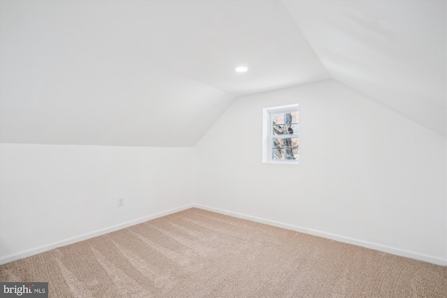 bonus room with carpet flooring and vaulted ceiling