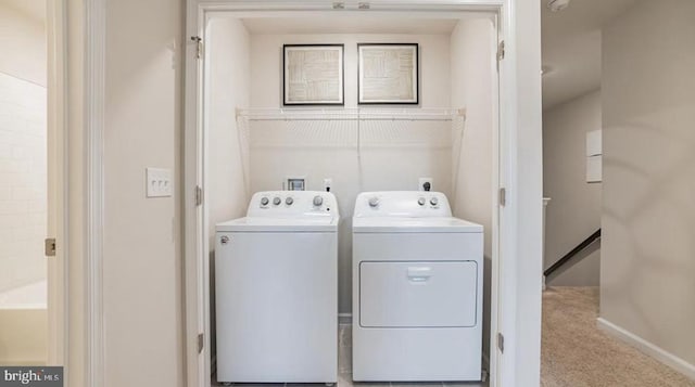 clothes washing area with washer and clothes dryer and light carpet