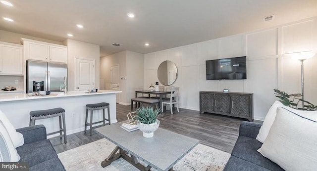 living room with dark hardwood / wood-style flooring and sink