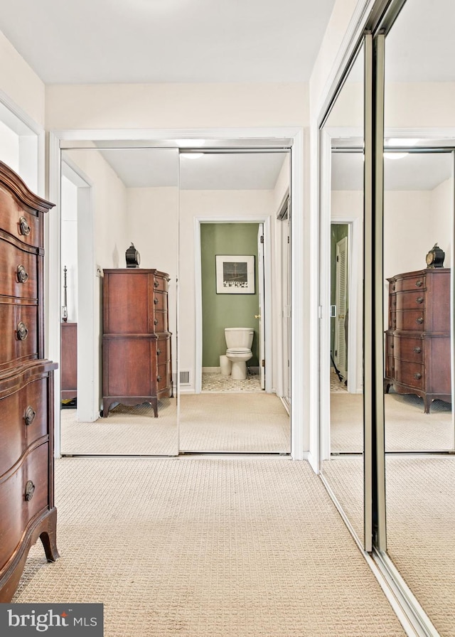 carpeted bedroom featuring connected bathroom and a closet