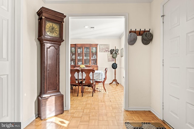 hallway with ornamental molding and light parquet floors