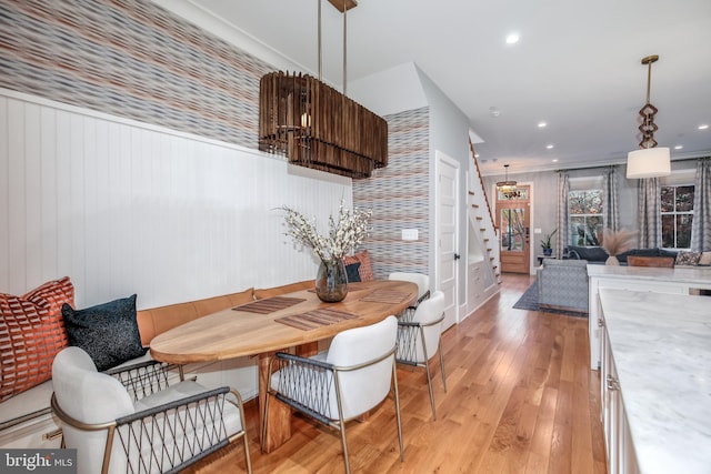 dining space featuring light wood-type flooring and wood walls