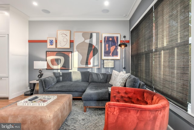 living room with light wood-type flooring and ornamental molding