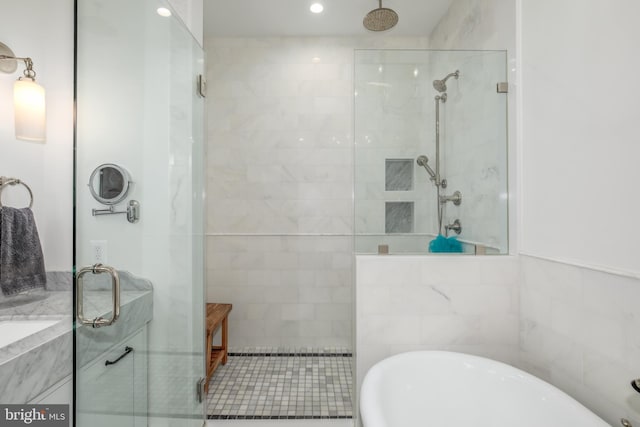 bathroom featuring independent shower and bath and tile walls