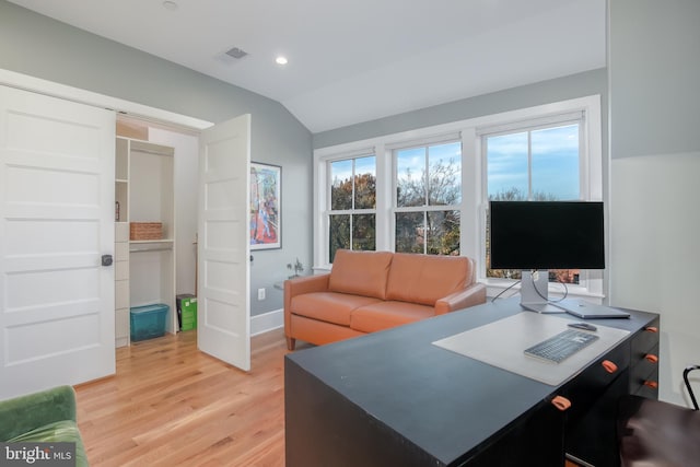 office area with light hardwood / wood-style floors and vaulted ceiling