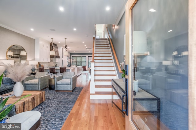 living room with ornamental molding and light hardwood / wood-style flooring