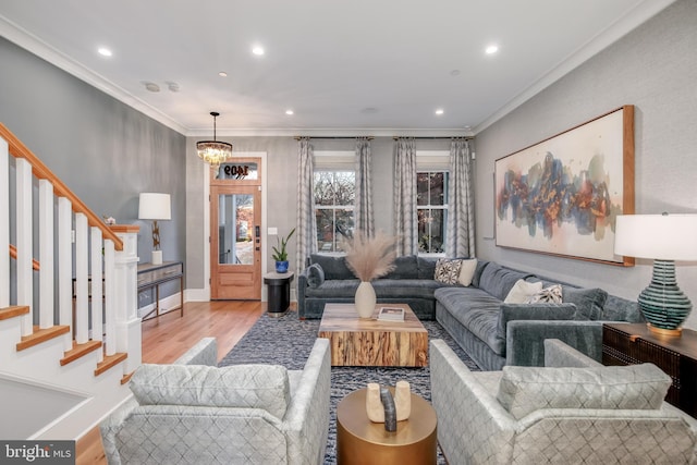 living room featuring light hardwood / wood-style flooring, ornamental molding, and a notable chandelier