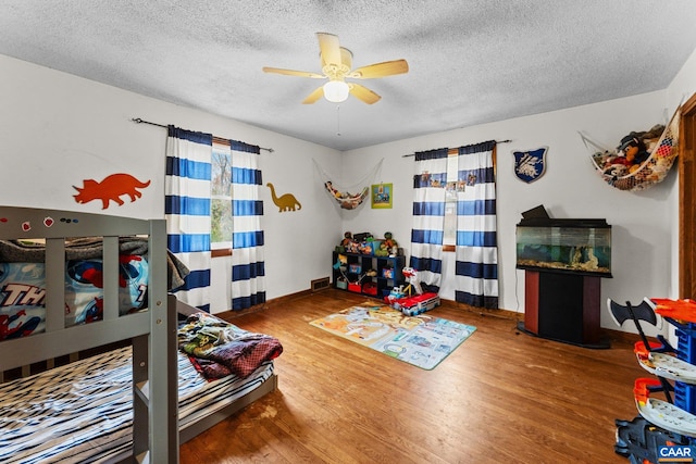 bedroom featuring hardwood / wood-style flooring, ceiling fan, and a textured ceiling