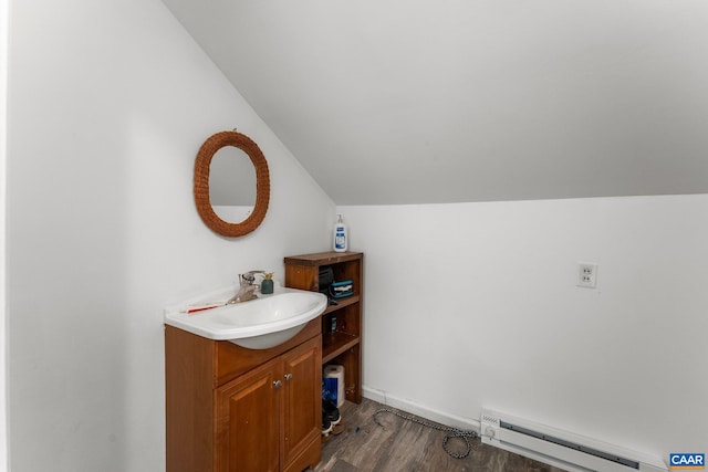 bathroom featuring vanity, wood-type flooring, baseboard heating, and vaulted ceiling