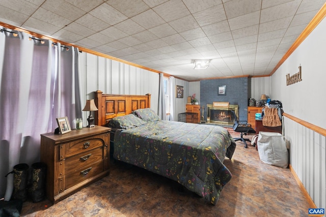 bedroom with crown molding and a brick fireplace