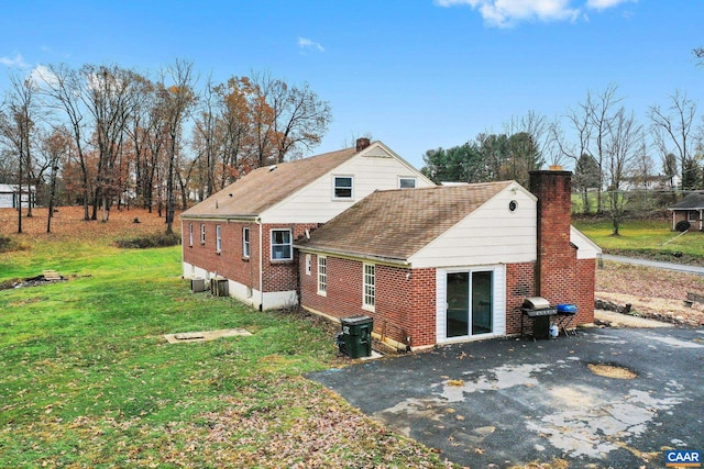 rear view of property featuring a lawn and a patio area