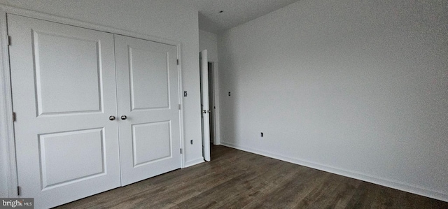 unfurnished bedroom with a closet and dark hardwood / wood-style floors