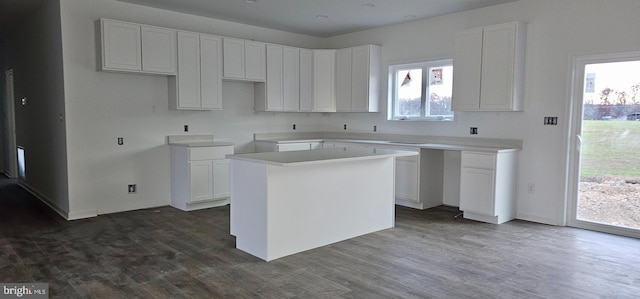 kitchen with white cabinetry, a center island, and dark wood-type flooring