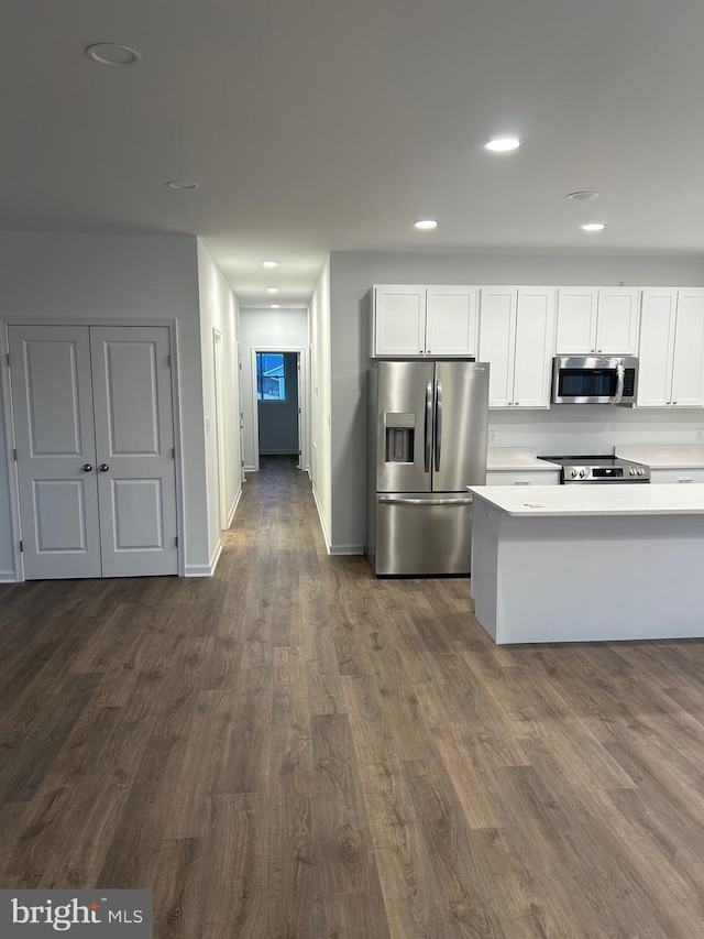 kitchen with white cabinetry, dark wood-type flooring, and stainless steel appliances