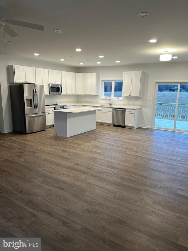 kitchen with dark wood-type flooring, sink, appliances with stainless steel finishes, ceiling fan, and white cabinets