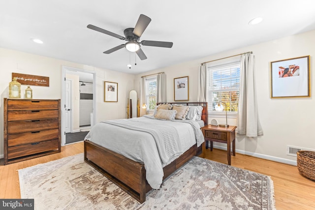 bedroom featuring hardwood / wood-style flooring, multiple windows, and ceiling fan