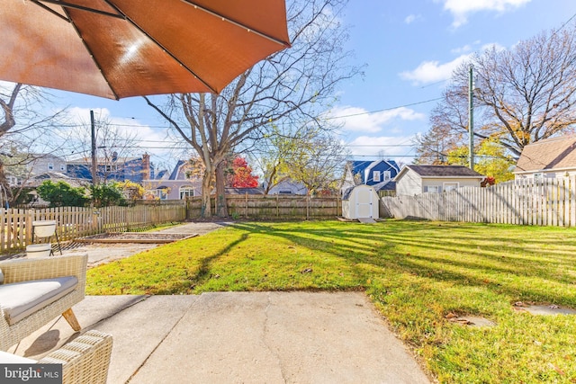 view of yard featuring a shed and a patio area