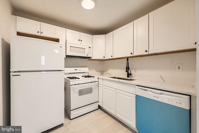 kitchen featuring light tile patterned flooring, white appliances, white cabinetry, and sink