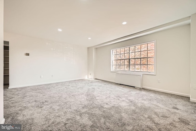 spare room featuring carpet flooring and radiator heating unit