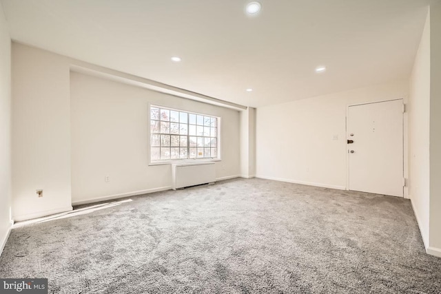 carpeted empty room with radiator heating unit