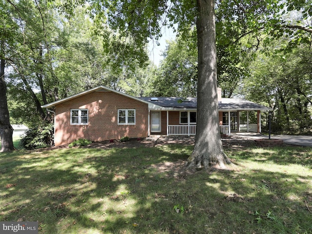 ranch-style home with covered porch and a front yard