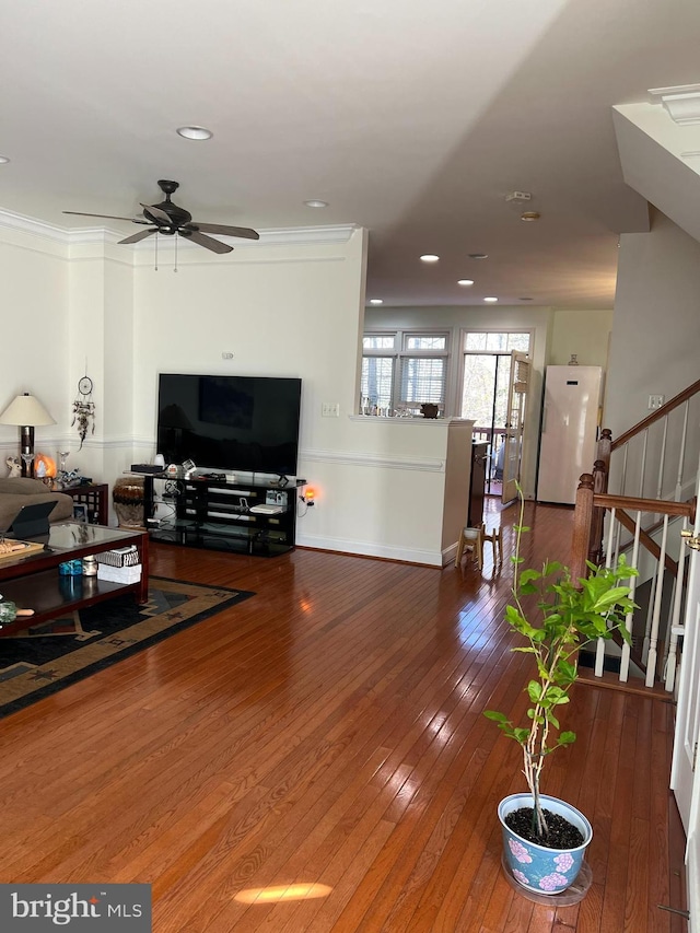 living room with hardwood / wood-style floors, ceiling fan, and crown molding