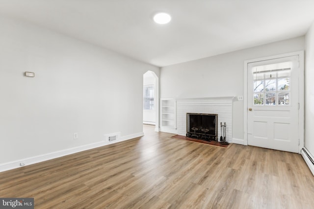 unfurnished living room featuring light wood-type flooring and a fireplace