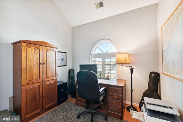 office space featuring hardwood / wood-style floors and high vaulted ceiling