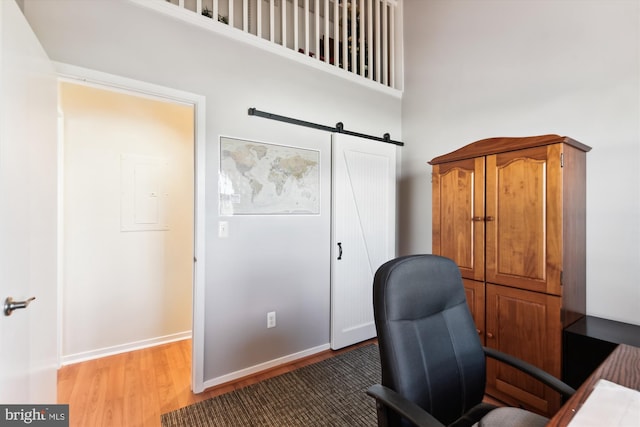 home office with a high ceiling and hardwood / wood-style flooring