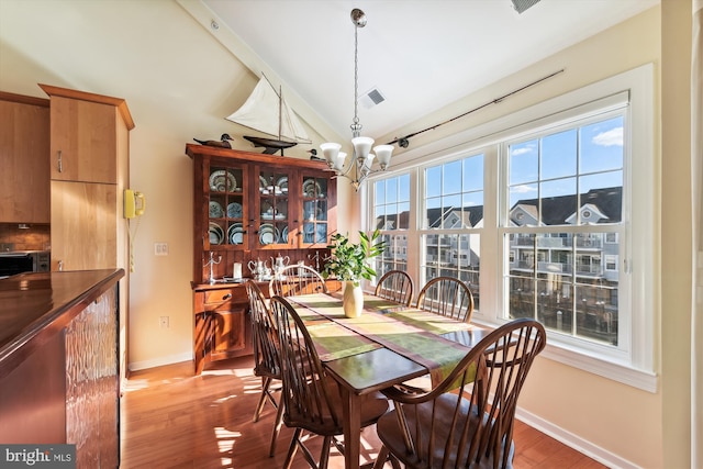 dining space with hardwood / wood-style floors and a chandelier