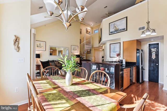 dining space with a high ceiling, dark hardwood / wood-style flooring, and ceiling fan