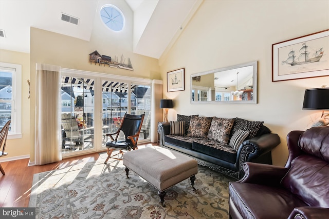 living room with hardwood / wood-style floors, beam ceiling, and high vaulted ceiling