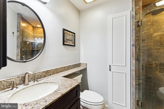 bathroom featuring vanity, toilet, and an enclosed shower