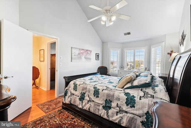 bedroom with ceiling fan, light wood-type flooring, and high vaulted ceiling