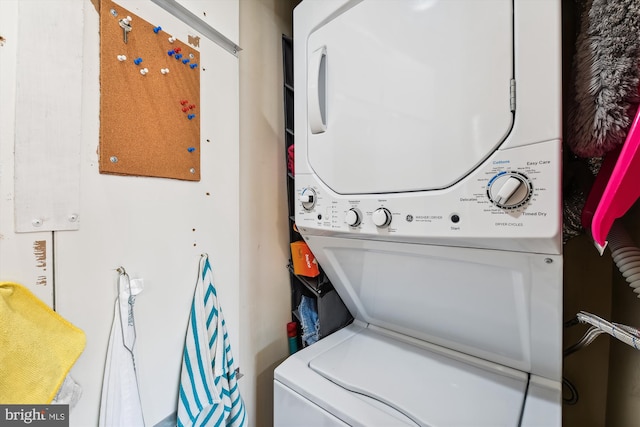 clothes washing area featuring stacked washer and clothes dryer