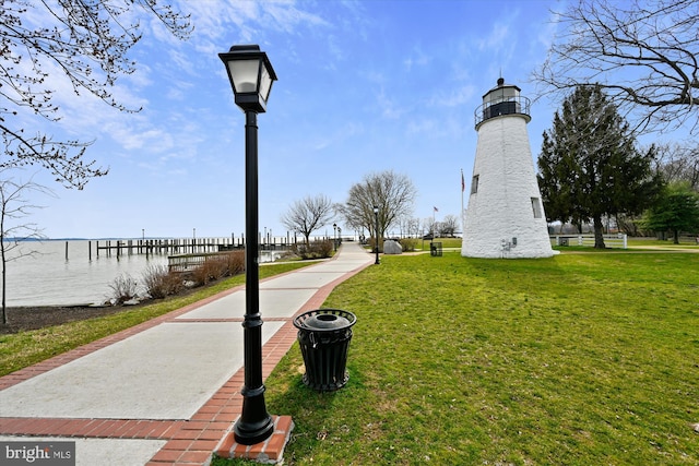 surrounding community featuring a water view and a lawn