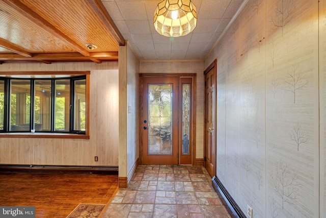 entryway featuring wood walls, plenty of natural light, wood-type flooring, and a baseboard heating unit