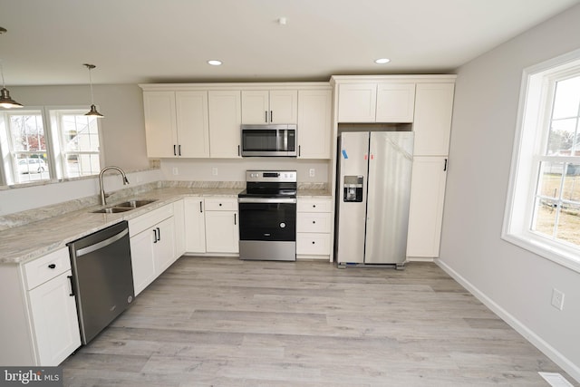 kitchen featuring appliances with stainless steel finishes, white cabinetry, and sink