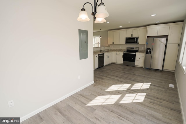 kitchen with electric panel, hanging light fixtures, light hardwood / wood-style flooring, stainless steel appliances, and a chandelier