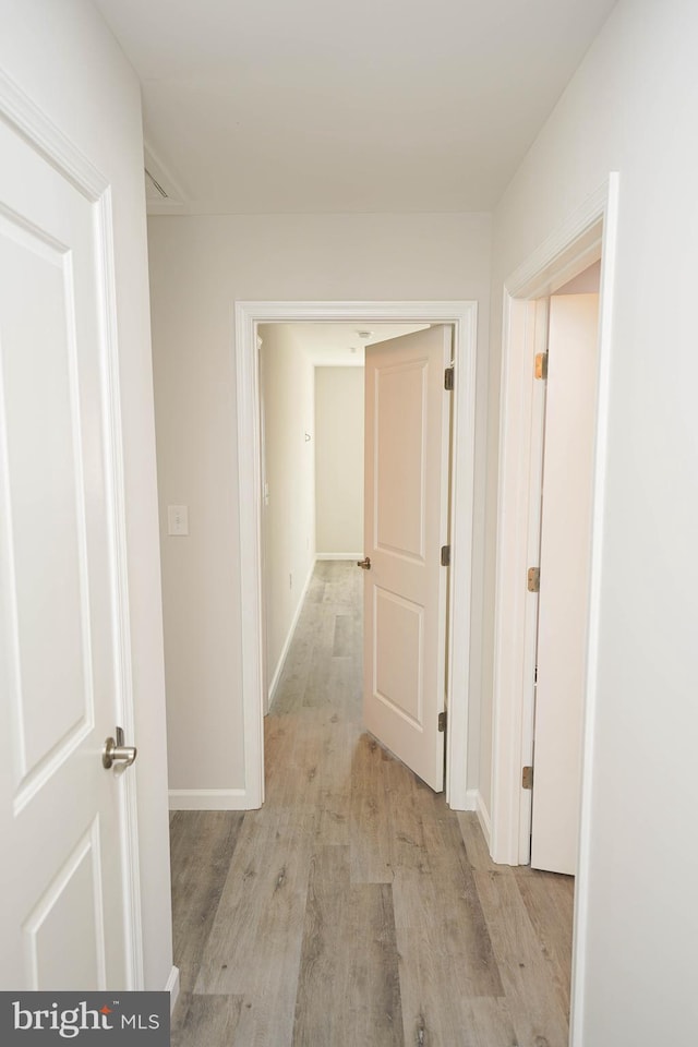 hallway with light hardwood / wood-style floors