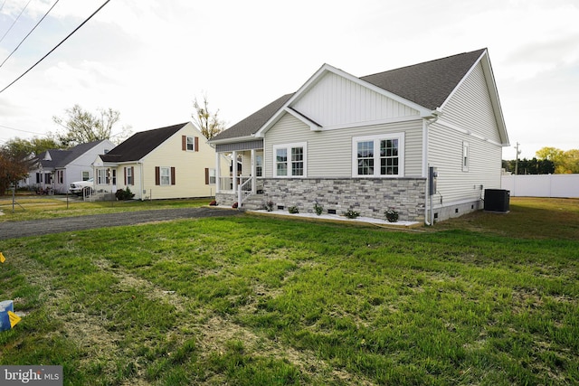 view of front of home featuring central AC unit and a front yard