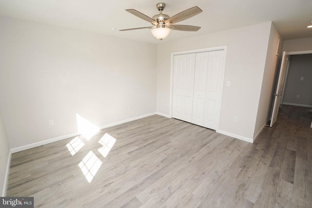 unfurnished bedroom with ceiling fan, a closet, and light hardwood / wood-style flooring