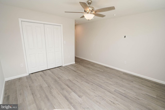 unfurnished bedroom featuring a closet, light hardwood / wood-style floors, and ceiling fan