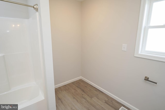 bathroom with wood-type flooring and tub / shower combination