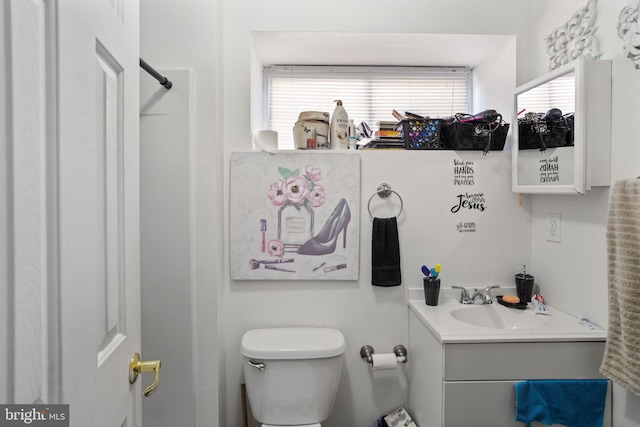 bathroom with a shower, vanity, and toilet