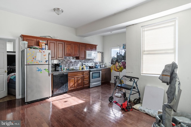 kitchen with tasteful backsplash, sink, appliances with stainless steel finishes, and dark wood-type flooring