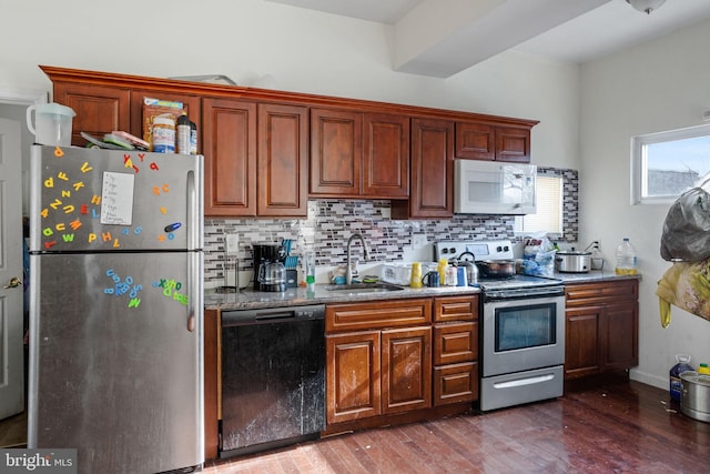 kitchen with sink, stainless steel appliances, tasteful backsplash, and dark wood-type flooring